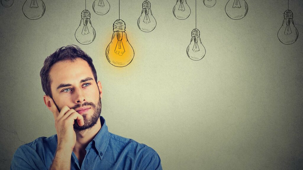 Man thinking with drawings of lightbulbs in the background
