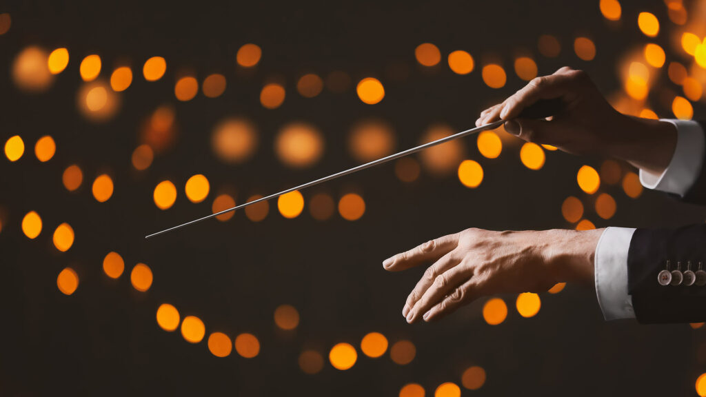 Conductor's hands against a bokeh background